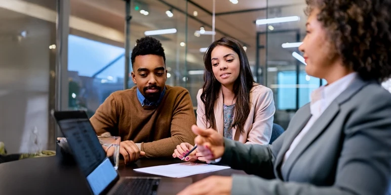 A couple sits with a financial adviser getting #AdviceForSuccess.
