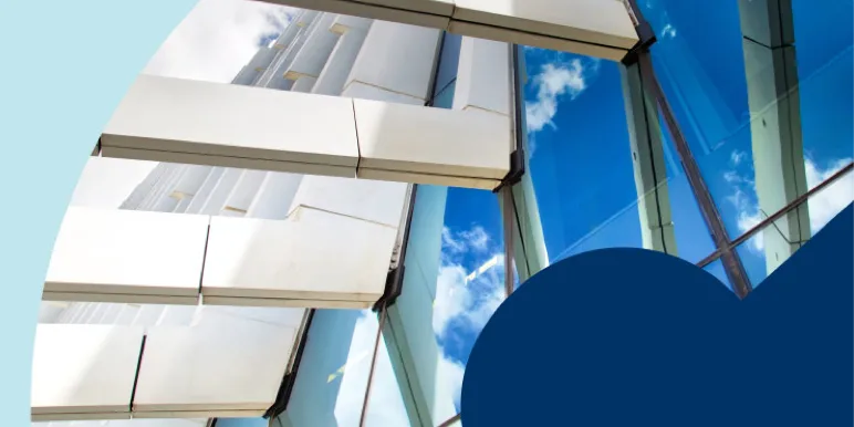 A web banner featuring a low-angle shot of a modern, glass skyscraper reflecting a bright blue sky with white clouds, symbolising an investment building.