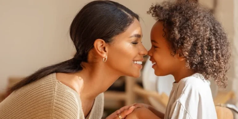  A happy mother and her curly-haired daughter smiling warmly at each other, representing a secured legacy for the next generation through estate planning.
