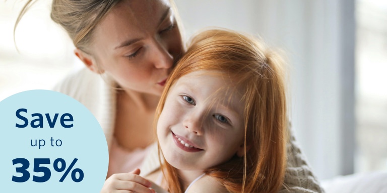 Mom kisses her young daughter on the head.