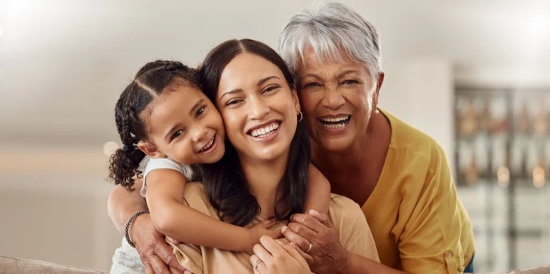 A mother, daughter and grandmother sharing a happy moment, enjoying the peace of mind that comes with financial security and knowing that investing for the long term can help build a secure future for generations to come.