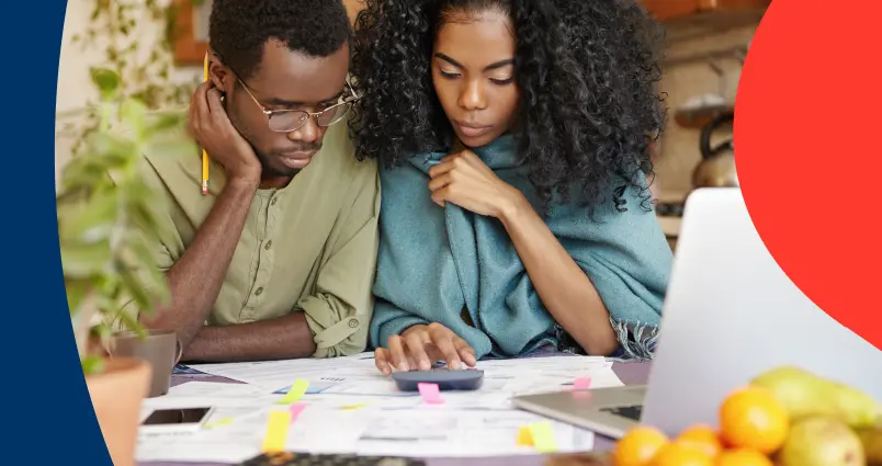 A couple partaking in DIY financial planning, using a calculator and reviewing their retirement annuity statements.