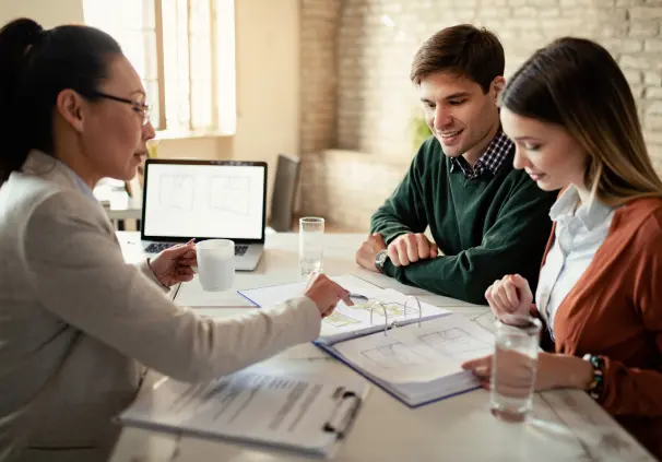  couple reviewing their investment portfolio with their financial adviser during a financial planning consultation.