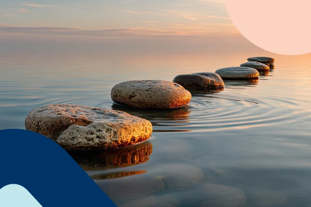 A curved path of smooth stepping stones stretching across calm water at sunset, creating gentle ripples that symbolise compound interest.