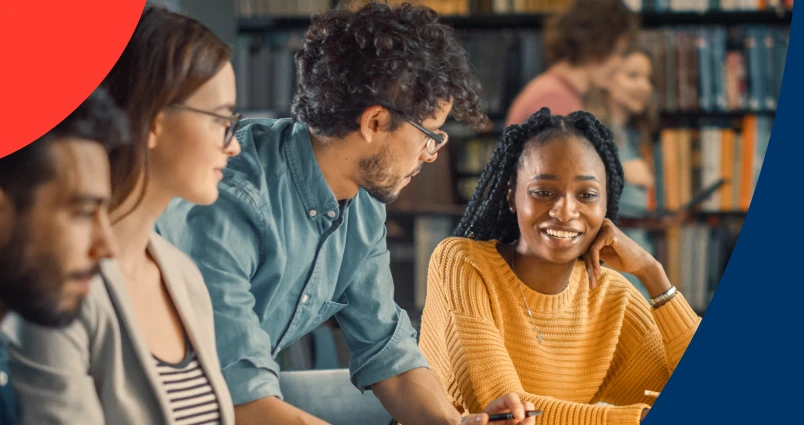 A group of students working together in a library setting, symbolising how an education savings plan supports their academic journey. 