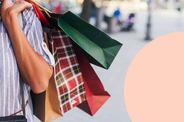 Close-up of a person carrying multiple retail shopping bags on their arm, illustrating the contrast between unnecessary spending and stagnant savings growth.