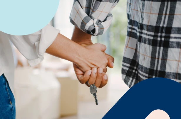 Close-up of a couple holding hands with a house key, symbolising the importance of home insurance protection.