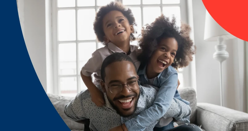 A smiling father spending quality time with his young son and daughter at home, symbolic of the important role father’s play in children’s financial journey from a young age.