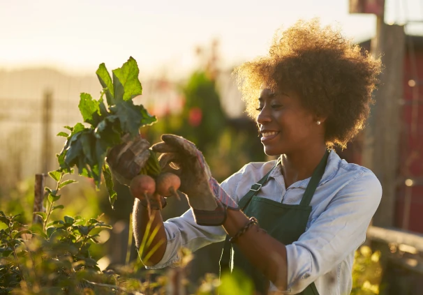 A woman gardening and nurturing her plants, representing retirement savings growth.