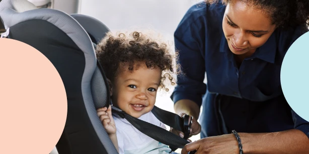 Image of a mother buckling up her toddler in a car seat.