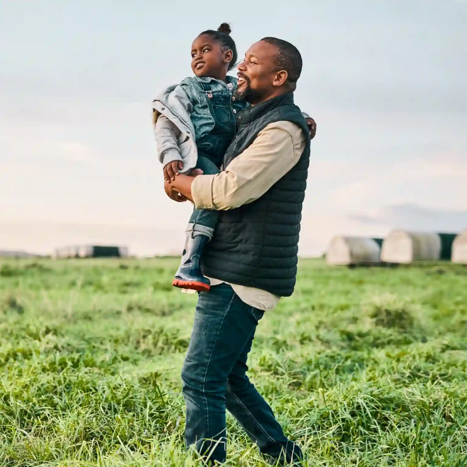 Father happily holding his child outdoors representing financial peace of mind and secure post-retirement income through Momentum Annuities.