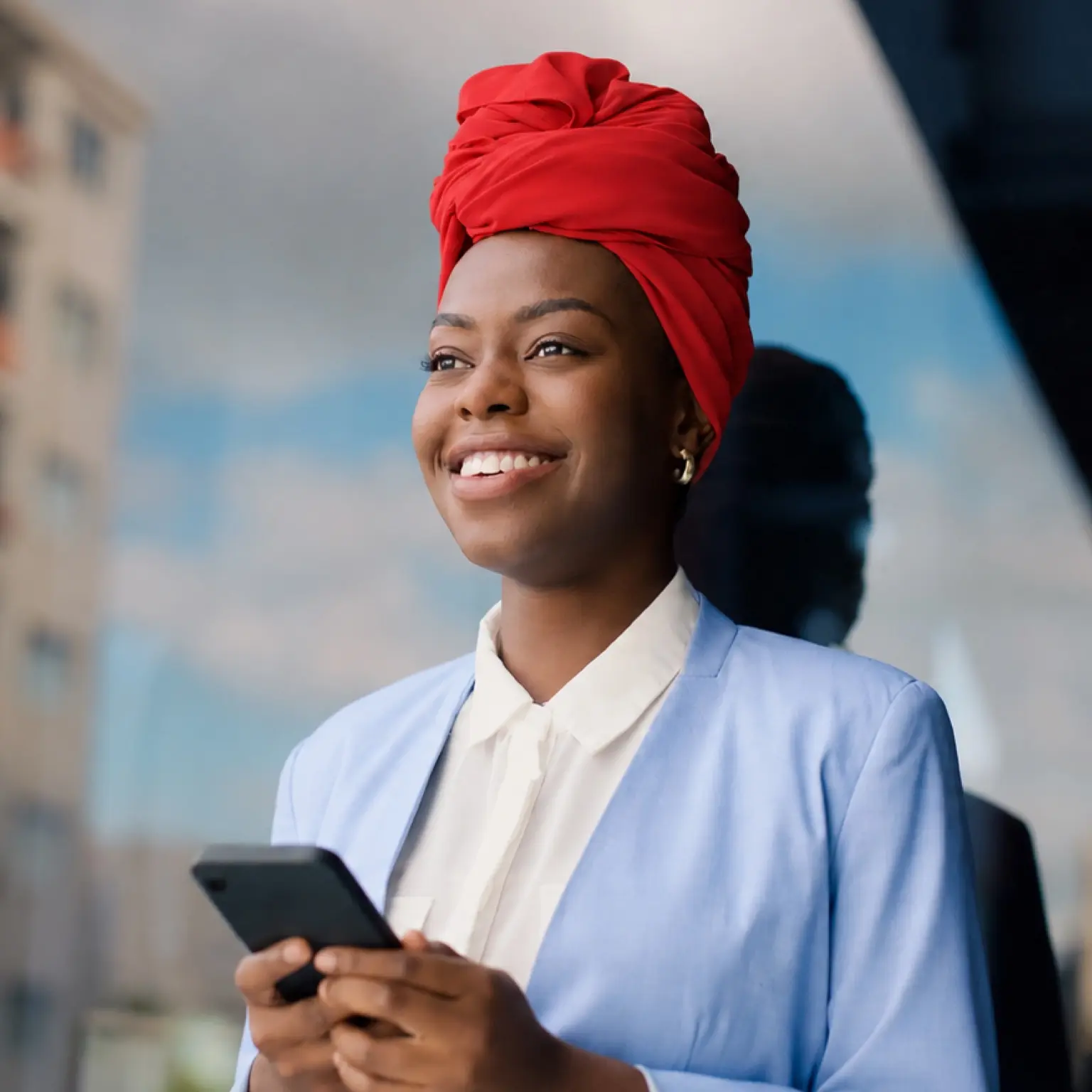 Professional woman with smartphone representing FundsAtWork value-added services and employee wellbeing benefits from Momentum.