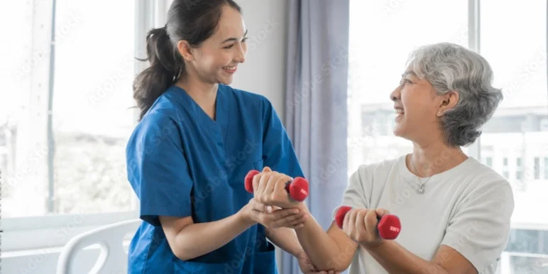 A man doing exercise with a blue elastic band in his hands while his observed by a physiotherapist.
