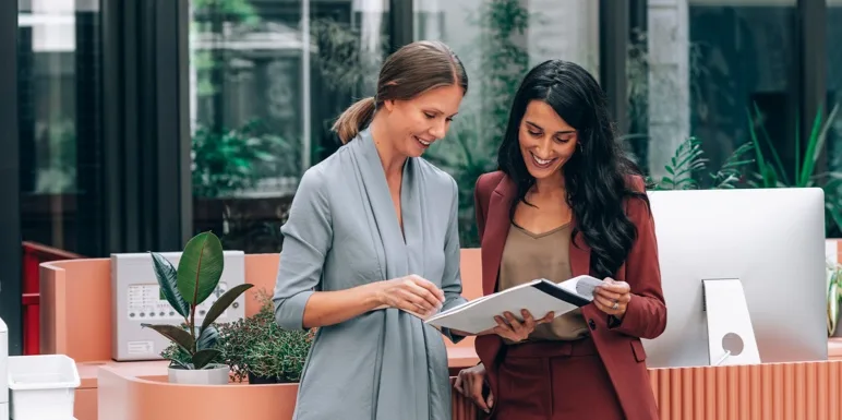 Two professional colleagues reviewing umbrella fund documents together in a modern office.
