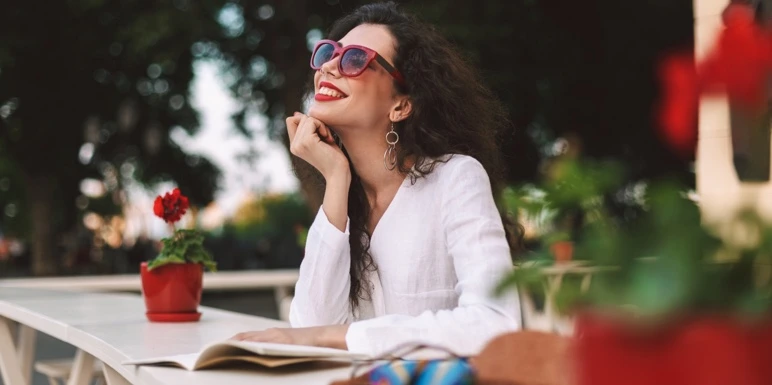 A smiling employee wearing sunglasses relaxing outdoors, representing peace of mind with group insurance coverage