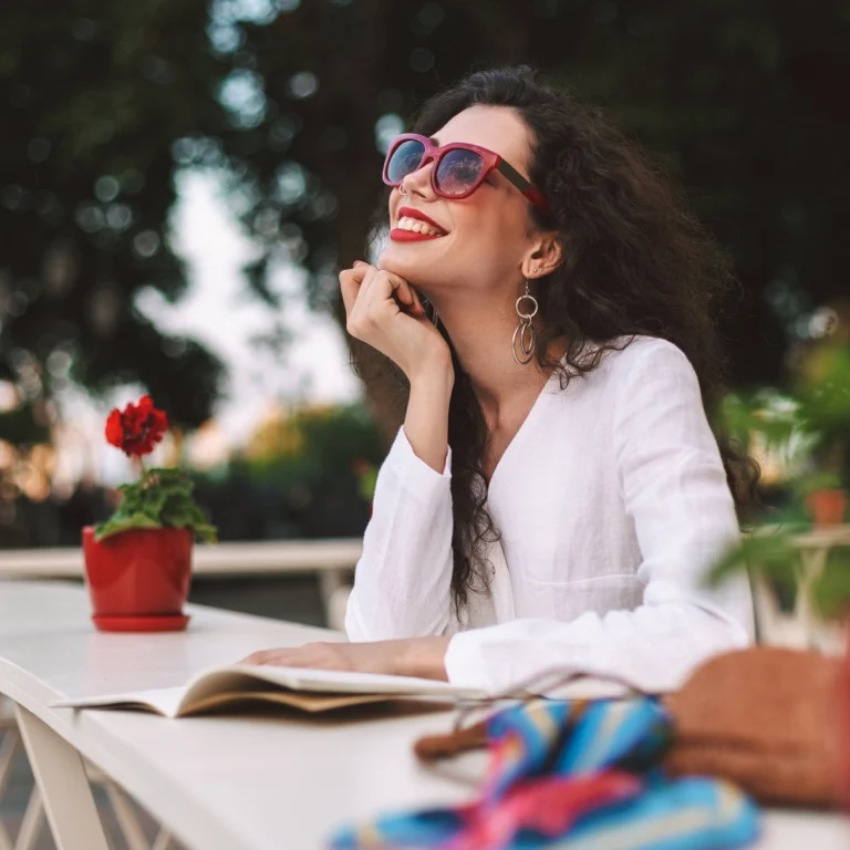 A smiling employee wearing sunglasses relaxing outdoors, representing peace of mind with group insurance coverage