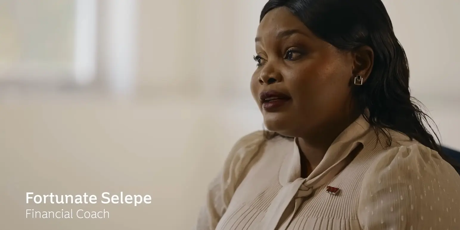Close-up of Fortunate Selepe, a Financial Coach at Momentum Corporate, speaking about employee benefits in an office setting.
