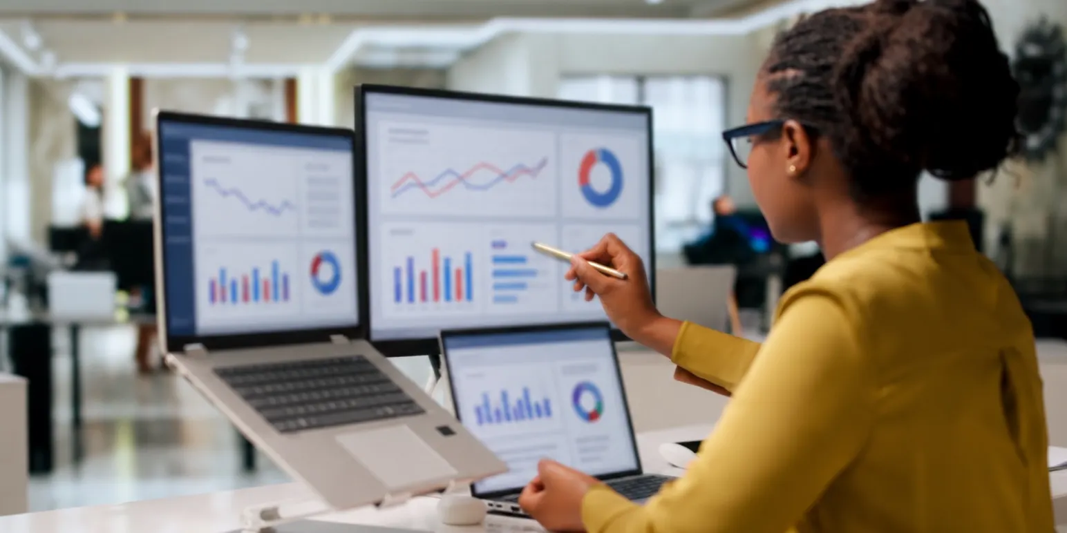 Financial administrator reviewing fund performance analytics on desktop monitors representing Momentum Retirement Administrators.