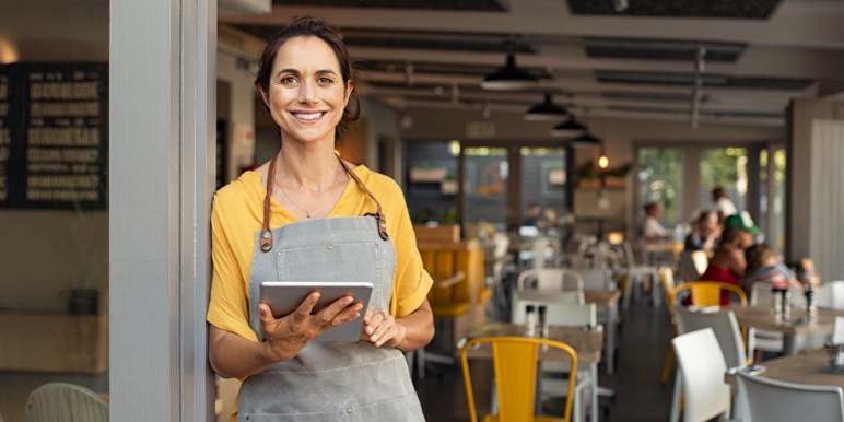 Confident business owner standing in her store, representing business continuity and success.