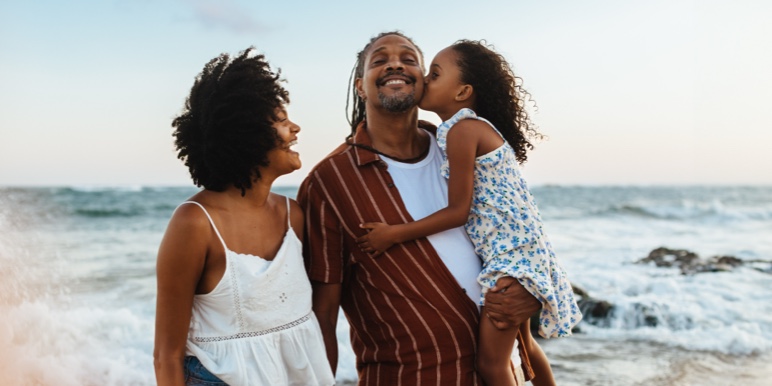 Happy family embracing on the beach, symbolising protection and security for loved ones.
