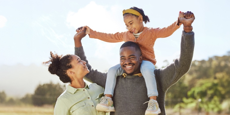 Parent playing with a child outdoors, reflecting good health and family wellbeing.