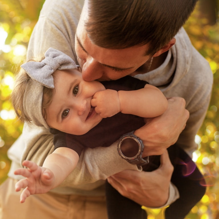 Dad playing outdoors with his young daughter.