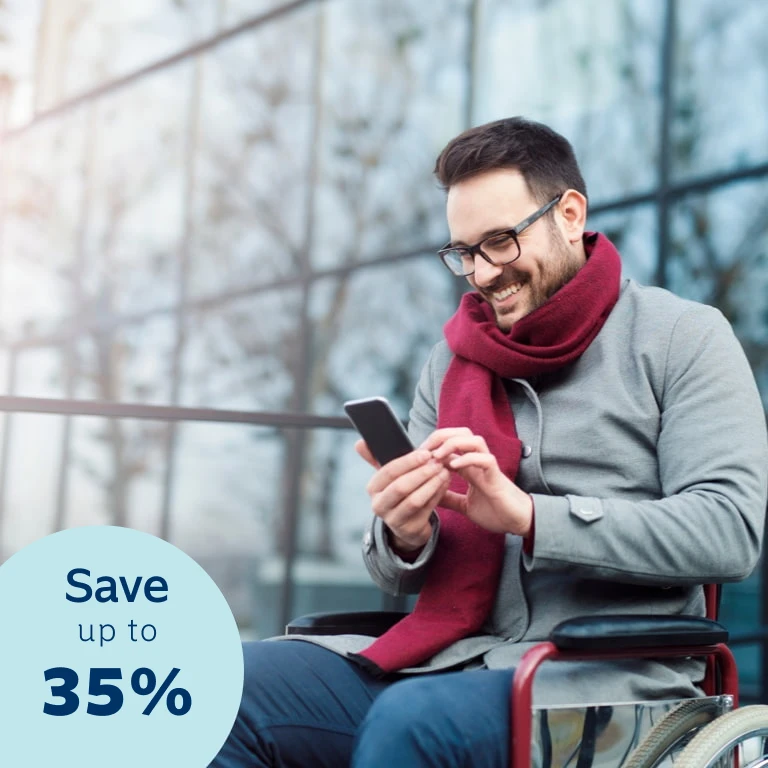 Young man seated in a wheelchair, busy doing an online disability cover quote on his cell phone. He’s smiling because he knows he could qualify for up to a 35% discount on his monthly premiums with Momentum Life Returns.