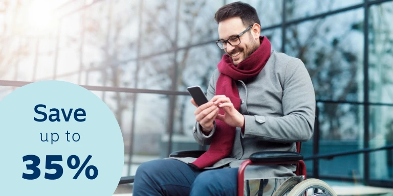 Young man seated in a wheelchair, busy doing an online disability cover quote on his cell phone. He’s smiling because he knows he could qualify for up to a 35% discount on his monthly premiums with Momentum Life Returns.