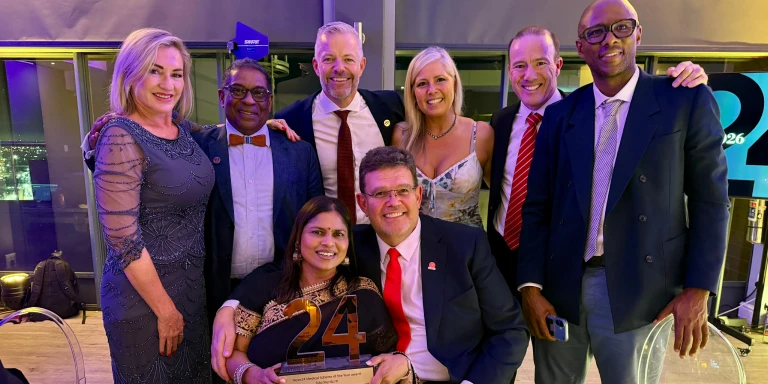Group of Momentum executives celebrating News24 Medical Scheme of the Year 2026 award, posing with trophy at an awards event.