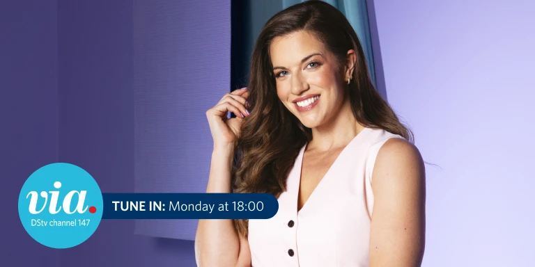 Smiling woman with long wavy brown hair wearing a sleeveless light pink top, posing against a purple and blue studio background. A graphic in the corner reads “via. DStv channel 147” and “TUNE IN: Monday at 18:00.