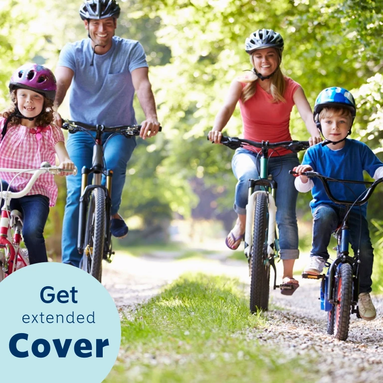 Happy mom and dad riding bicycles outdoors with their two children riding their bicycles ahead of their mother and father.