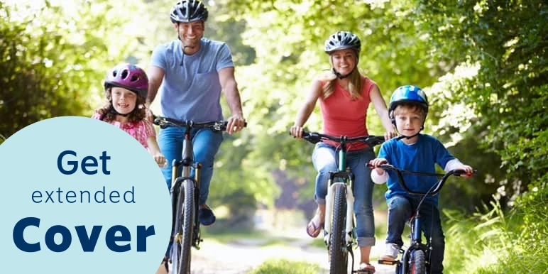 Happy mom and dad riding bicycles outdoors with their two children riding their bicycles ahead of their mother and father.