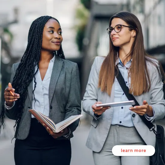 Two female professionals in conversation about their future goals and long-term savings.