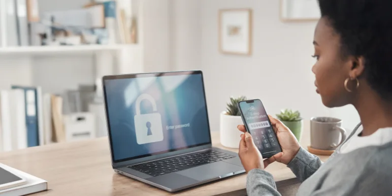 A person holding a cell phone and entering a one-time PIN to complete a secure website login as part of the multi-factor authentication process.