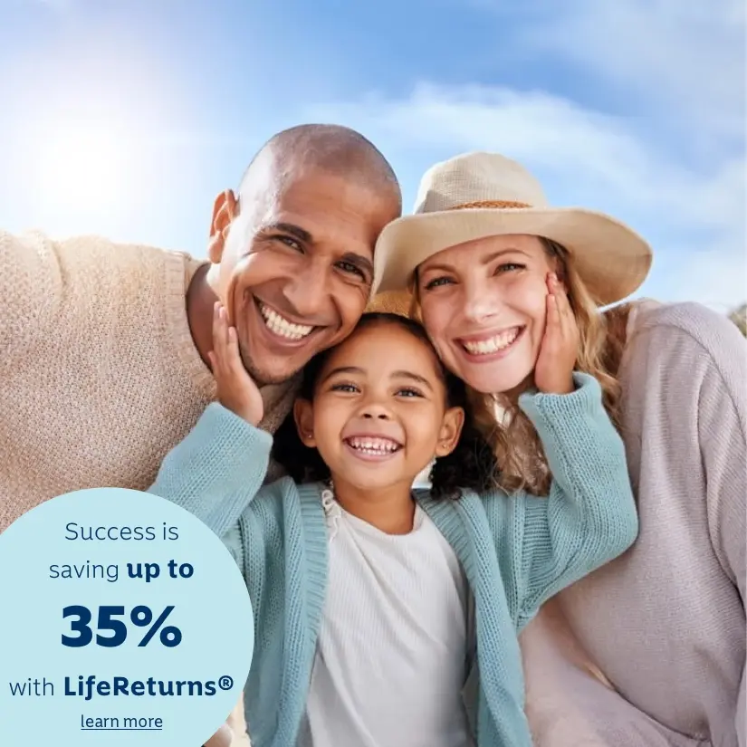 Parents enjoy a day outdoors with their young daughter. The daughter is standing in the middle of them with her hands on each parent's cheeks.