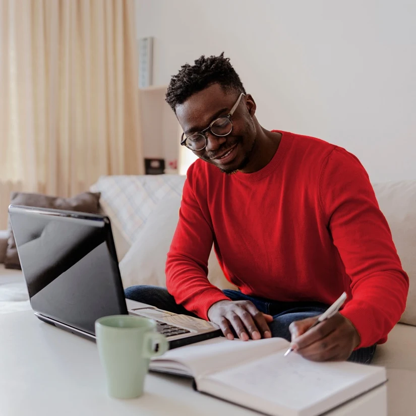 A young man who is journalling his intentions for his family, while starting the estate plan process to draft an executable Will during Wills Month.