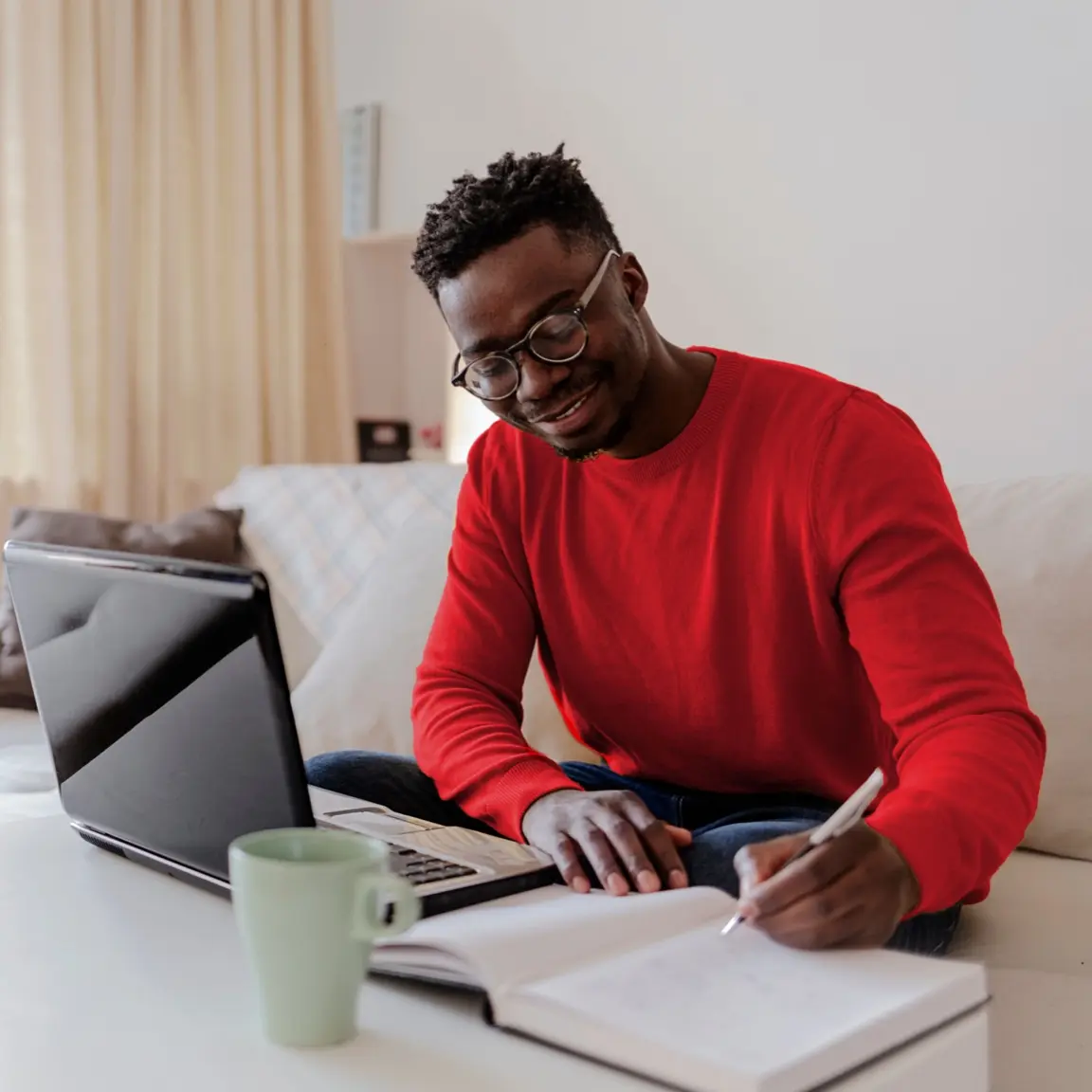 A young man who is journalling his intentions for his family and loved ones, while starting the estate plan process to draft an executable Will during Wills Month.
