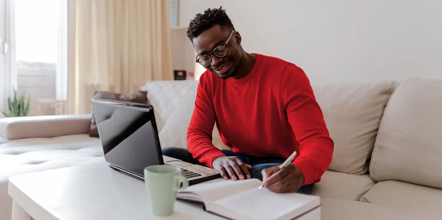 A young man who is journalling his intentions for his family and loved ones, while starting the estate plan process to draft an executable Will during Wills Month.